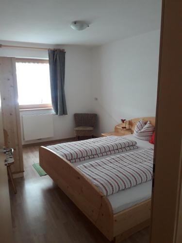 a bedroom with a large bed with a window at Hofstatthof in Campo di Trens