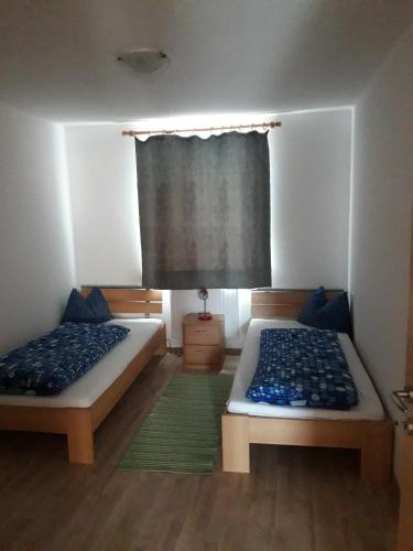 a bedroom with two beds and a window with a curtain at Hofstatthof in Campo di Trens