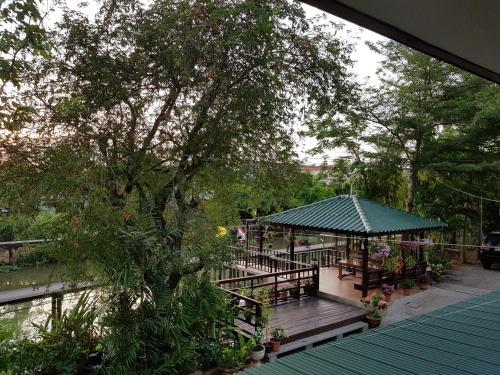a building with a gazebo next to a river at Songthai Suvarnabhumi in Ban Khlong Si