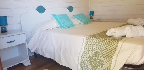 a bedroom with a large white bed with blue pillows at Agriturismo Sa Pigalva in Tula