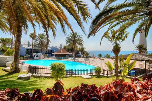 Playa del AguilaにあるExtra Luxury Apartament beachfront balconyのヤシの木と海を背景にしたプール
