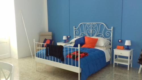 a blue bedroom with a bed with orange pillows at La Campanella Lipari in Acquacalda