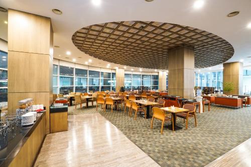 uma área de refeições com mesas e cadeiras num restaurante em Gumi Century Hotel em Gumi
