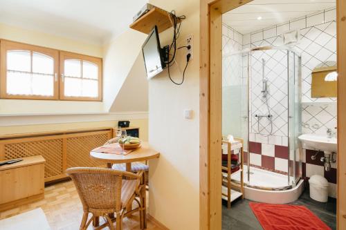 a bathroom with a shower and a table and a sink at Gästehaus Pension Lang in Pfarrkirchen im Mühlkreis