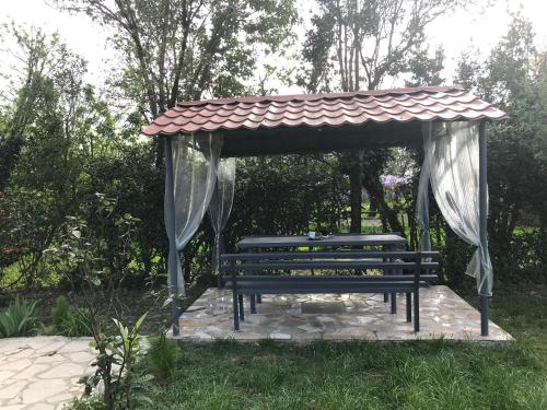 a bench with a gazebo in a park at Sweet Memories in Kutaisi