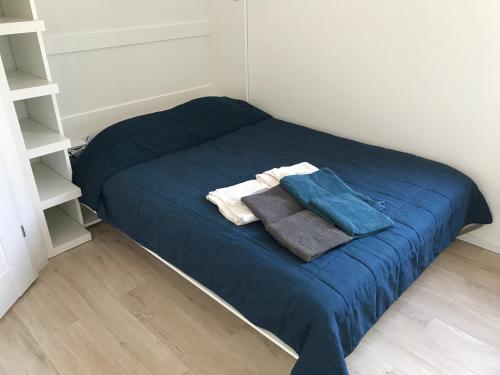 a small bedroom with a blue bed with towels on it at Apartament bursztynowy in Jantar