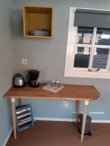 a wooden table in a room with a window at B&B Pipowagen "de Luxe" op Wellness Camping en B&B in Meddoo