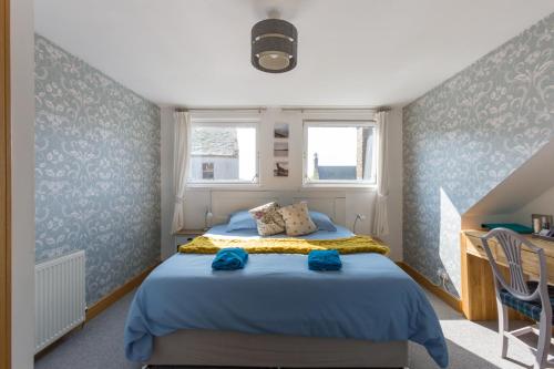 a bedroom with a bed with blue walls and a desk at Bamse B&B in Montrose