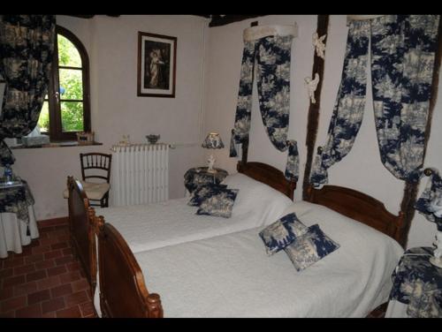 a bedroom with two beds and a window at La Petite Ferme in Vouzeron