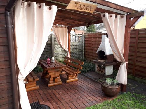 patio z drewnianą pergolą i sprzętem do grillowania w obiekcie Tajek w Stegnie