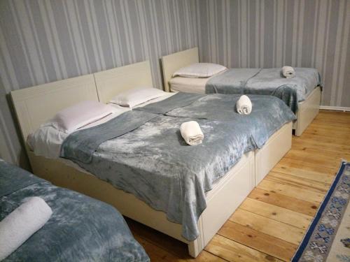 two twin beds in a room with wood floors at Abramichi Guest House in Sighnaghi