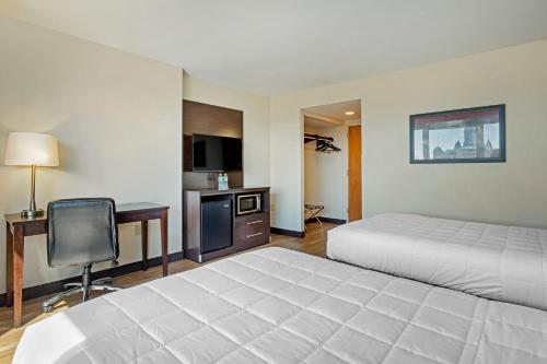 a hotel room with two beds and a desk and a chair at The Capitol Hotel in Hartford