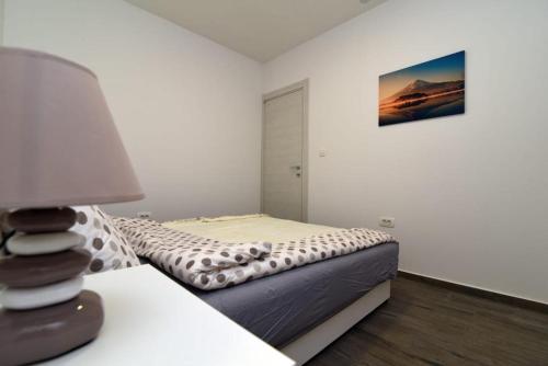 ein Schlafzimmer mit einem Bett und einem Tisch mit einer Lampe in der Unterkunft Apartment PAOLA in Zadar