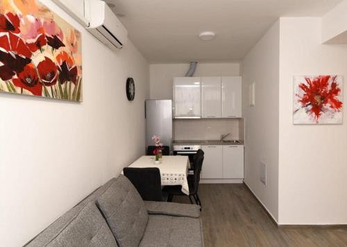 ein Wohnzimmer mit einem Sofa und einem Tisch sowie eine Küche in der Unterkunft Apartment PAOLA in Zadar