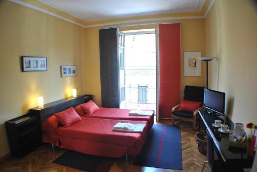 a living room with a red couch and a window at Alma Clara B&B in Turin