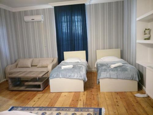 sala de estar con 2 camas y sofá en Abramichi Guest House, en Signagi