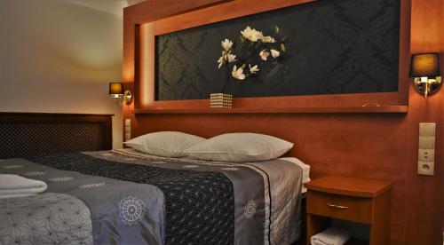 a bedroom with a bed with a picture on the wall at Hotel Złote Dęby in Warsaw