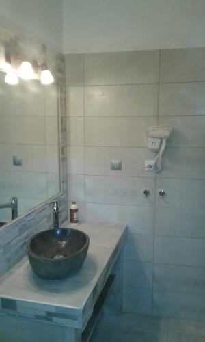 a bathroom with a stone sink and a mirror at Menelaos Apartments in Lefokastro