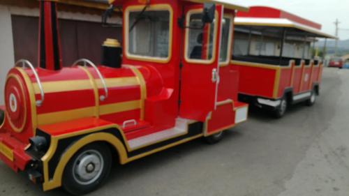 a red and yellow toy train parked next to a building at Pensiunea La Poarta Bucovinei in Suceava