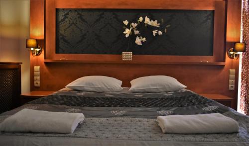 a bed with two pillows and a picture of flowers on it at Hotel Złote Dęby in Warsaw