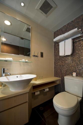 a bathroom with a sink and a toilet and a mirror at Wifi Boutique Hotel in Hong Kong