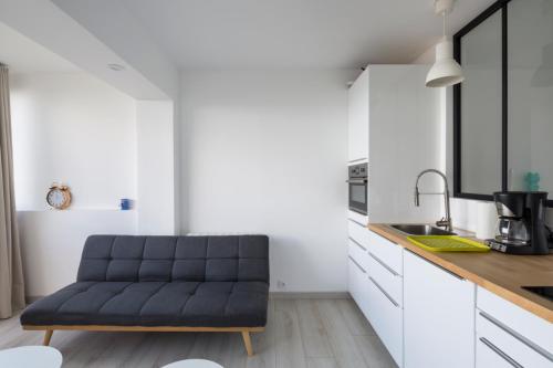 un salon avec un canapé dans une cuisine dans l'établissement Ker Romain - Studio - Vue Mer 180 degres, à Saint-Malo