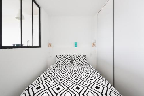 une chambre blanche avec un lit et une fenêtre dans l'établissement Ker Romain - Studio - Vue Mer 180 degres, à Saint-Malo