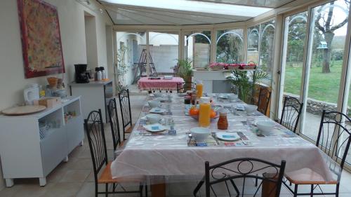 een eetkamer met een lange tafel met stoelen bij chambre d'hôtes mansardée in Saint-Ouen-les-Vignes