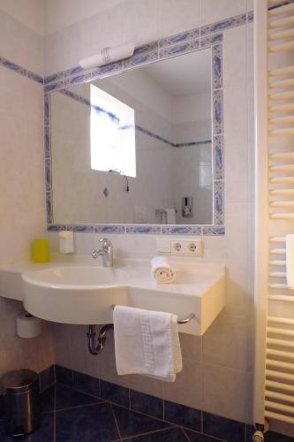 a bathroom with a sink and a mirror at Hotel Residence Olympia in Sarntal