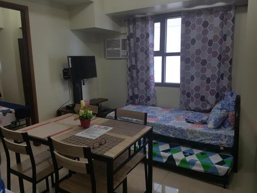 Habitación pequeña con mesa y cama en KC 1-Bedroom 1 at Horizon 101 Cebu, en Cebú