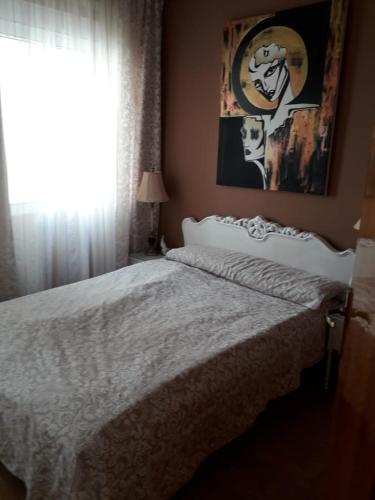 a bedroom with a bed and a window with a picture at Carrer Roma in Sagunto