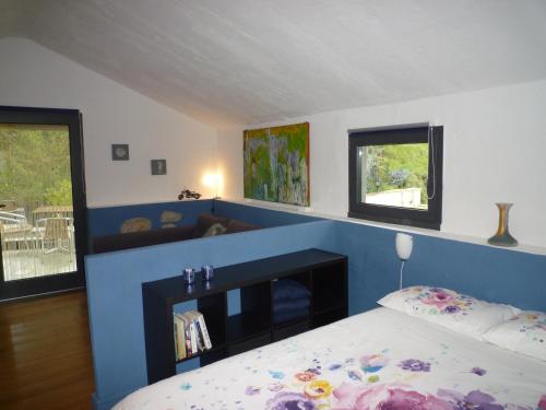 1 dormitorio con cama y pared azul en Fraseneggi, en Maissana