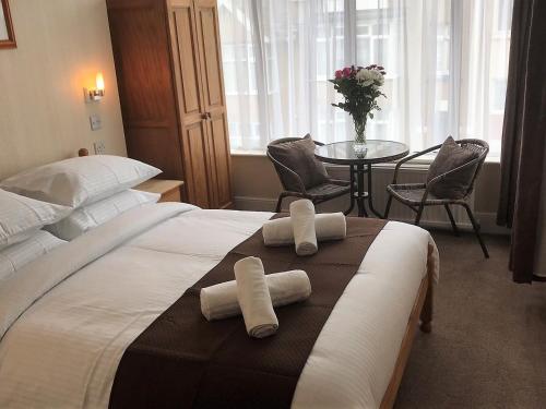 a bedroom with a bed and a table with chairs at Trevellis Bed and Breakfast in Newquay