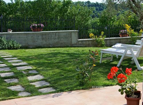 a garden with a white picnic table and flowers at Residence Ai Campi Da Golf Saturnia in Saturnia