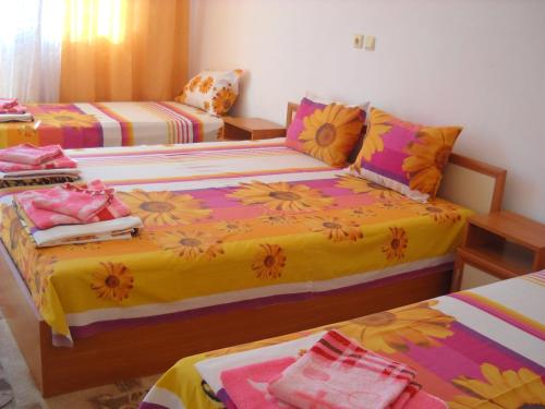 a bedroom with two beds with colorful sheets at Sani Family Hotel in Byala