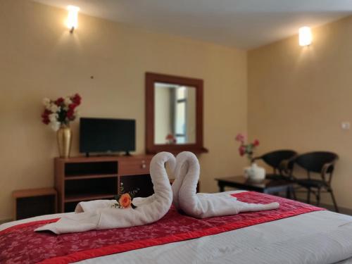two swans made out of towels on a bed at Paradise Wild Hills Kodachadri in Kollūru