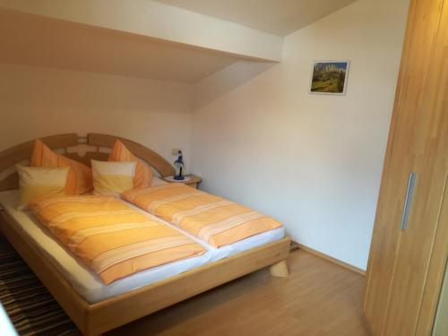 a bedroom with a bed with orange and yellow sheets at Örglgut in Werfenweng