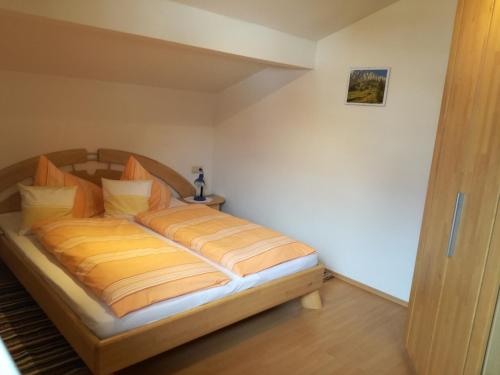 ヴェルフェンヴェンクにあるÖrglgutのベッドルーム1室(オレンジと黄色のシーツが入ったベッド1台付)