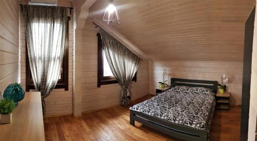 1 dormitorio con 1 cama y 2 ventanas en Lazur Hills, en Sanzhiyka