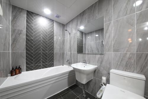 een badkamer met een wastafel, een bad en een toilet bij Eco Hotel in Mokpo