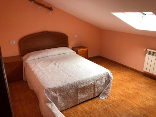 a bedroom with a large bed and a skylight at B&B O Barqueiro in O Barqueiro