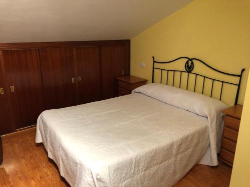 a bedroom with a large bed and wooden cabinets at B&B O Barqueiro in O Barqueiro