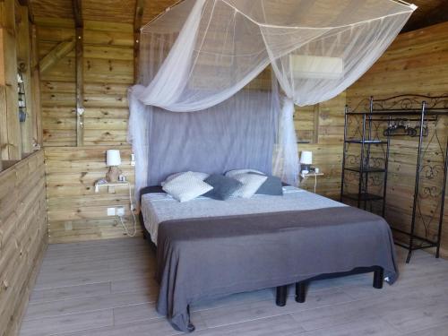 BUNGALOW La Tortue Bleue في بويانت: غرفة نوم بسرير مع مظلة