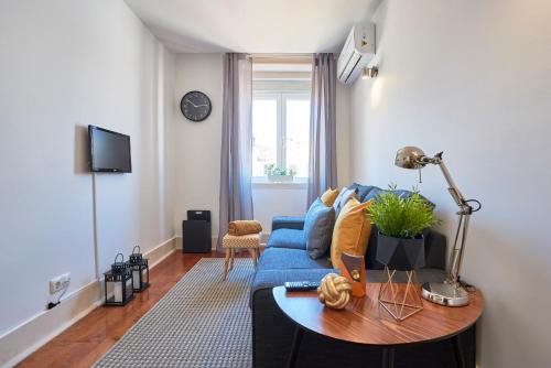 a living room with a blue couch and a table at Casa Portuguesa Chiado 25 in Lisbon