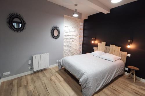 a bedroom with a large bed and a mirror at Le bon'appart - 50m de la cathédrale in Montauban