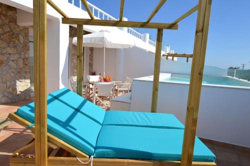 a patio with blue chairs and a swimming pool at Kathara Bay Apartments in Faliraki