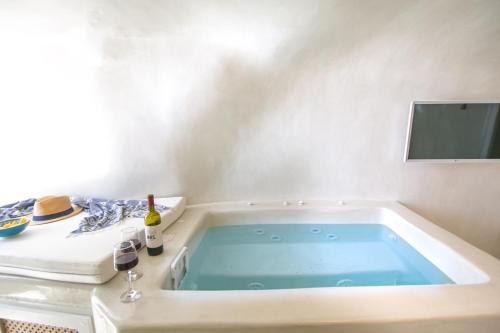a jacuzzi tub in a room with a tv at White Cave House in Oia