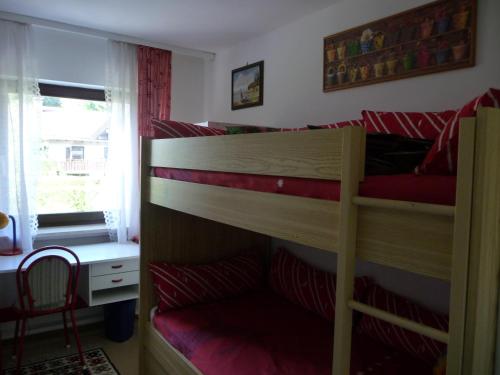 2 Etagenbetten in einem Zimmer mit einem Schreibtisch und einem Fenster in der Unterkunft Ferienhaus Werthmann in Mittenwald