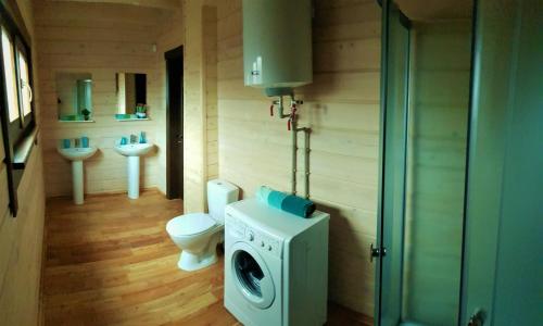 uma casa de banho com uma máquina de lavar roupa e um WC em Lazur Hills em Sanzhiyka
