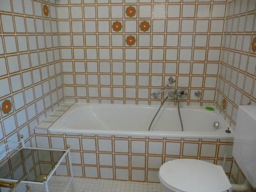 a bathroom with a bath tub and a toilet at Ferienhaus Werthmann in Mittenwald